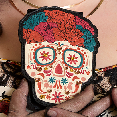 Teal background with model showing close up of Where the Wild Things are wallet