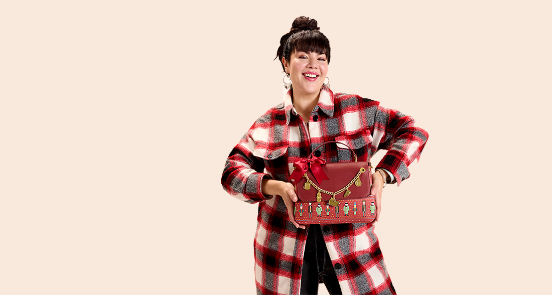 Solid colored Tan background with model showcasing Loungefly Home Alone accessories