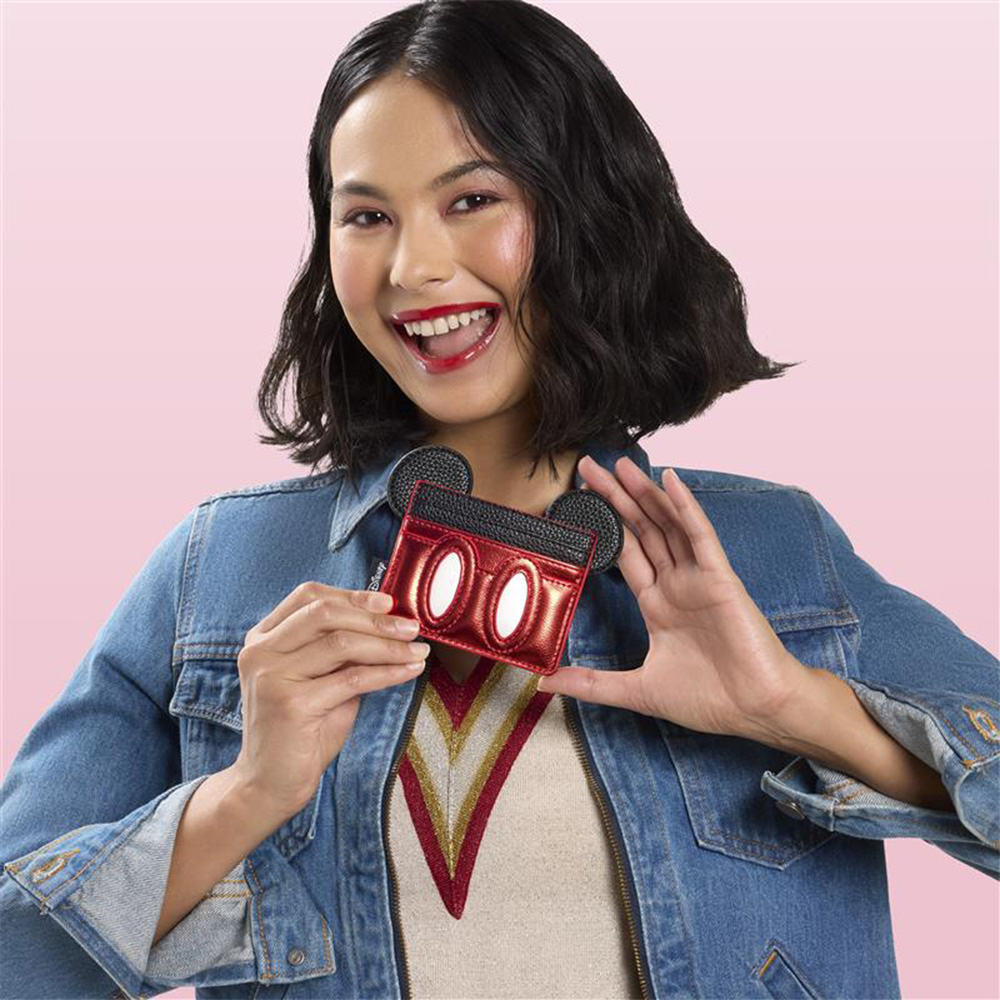 Pink background with model showcasing Loungefly Mickey Mouse wallet