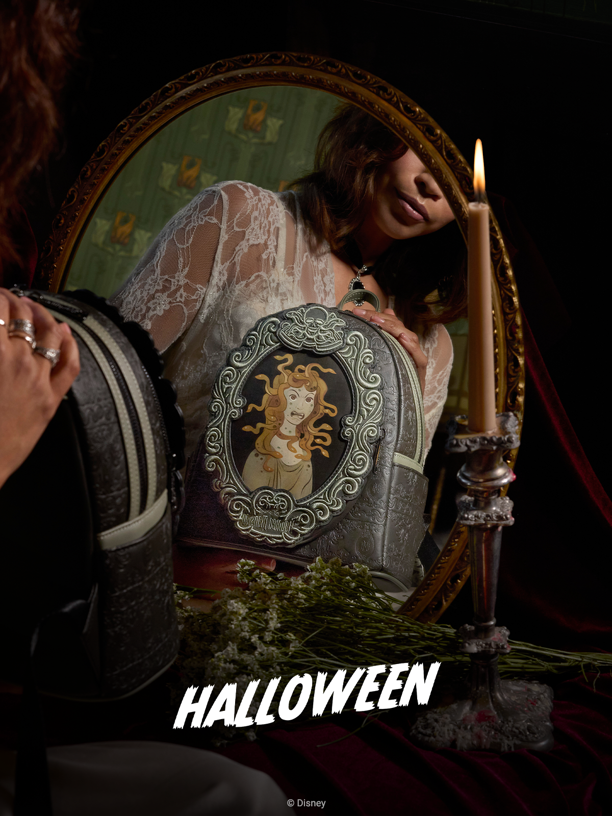 Dark vanity background with mirror reflecting Loungefly Disney Haunted Mansion Medusa Portrait Mini Backpack